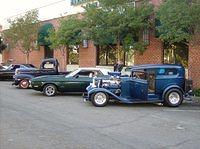 hot rods parked against brick building